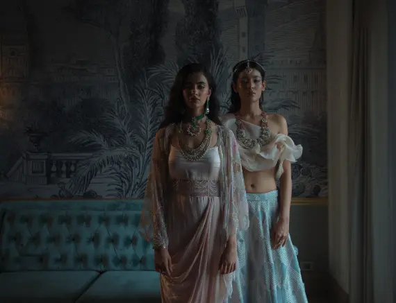 Two young women wearing heavy Polki jewellery in an artwork